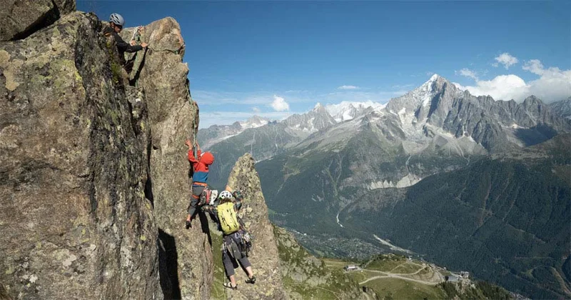 Parents rock climbing with their kids.