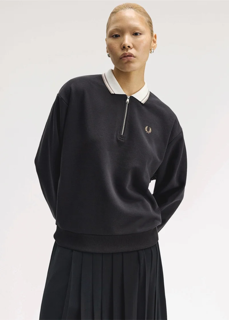 Female model wears quarter zip long sleeved black sweatshirt with white contrast collar