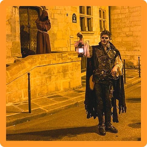 Image description: A person dressed as a vampire with skeleton make-up holding a lantern.