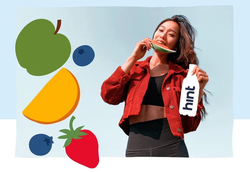 Women eats a watermelon while holding a Hint bottle