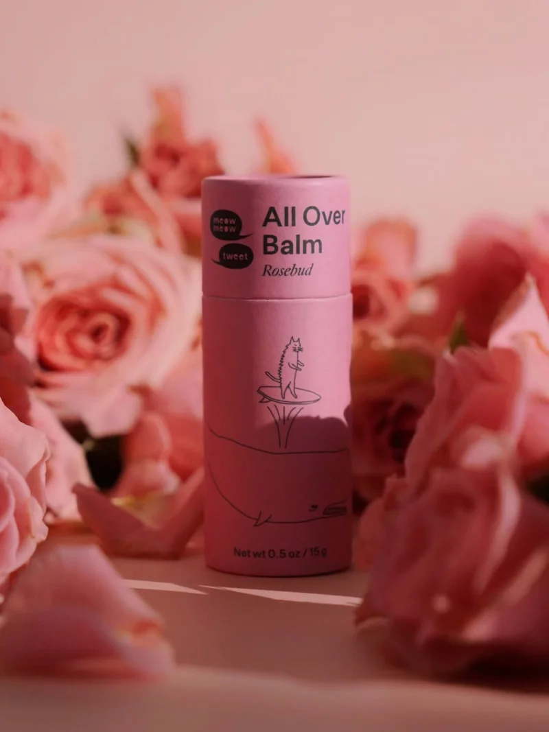 A pink paper tube against a pile of pink roses
