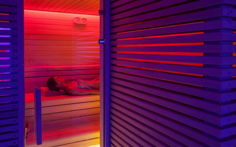 A woman lies down in a heated sauna.