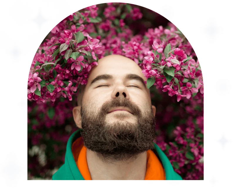 Man outdoors enjoying nature with flowers over his head