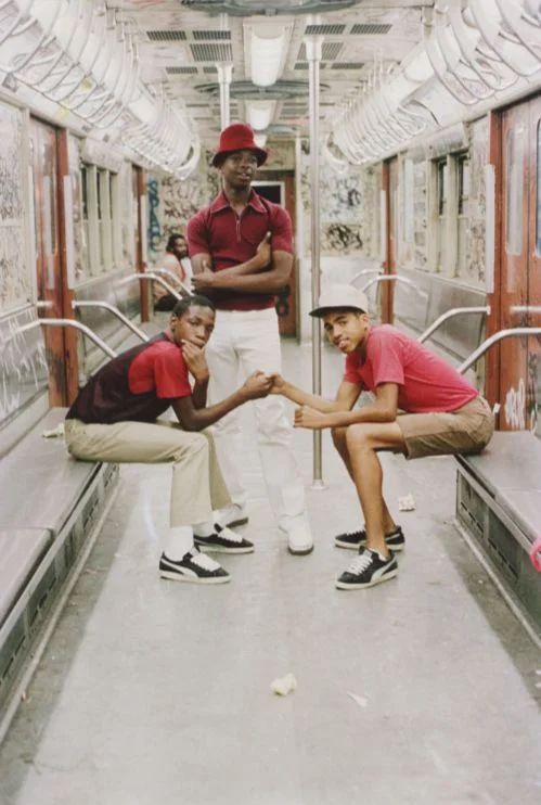 Three boys pose in a subway car