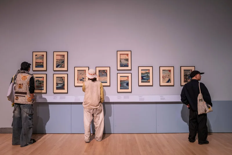 Three visitors standing in front of two artworks