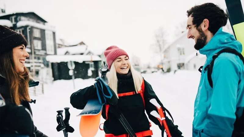 Image description: Group of friends talking and laughing at ski resort, on a winter day.