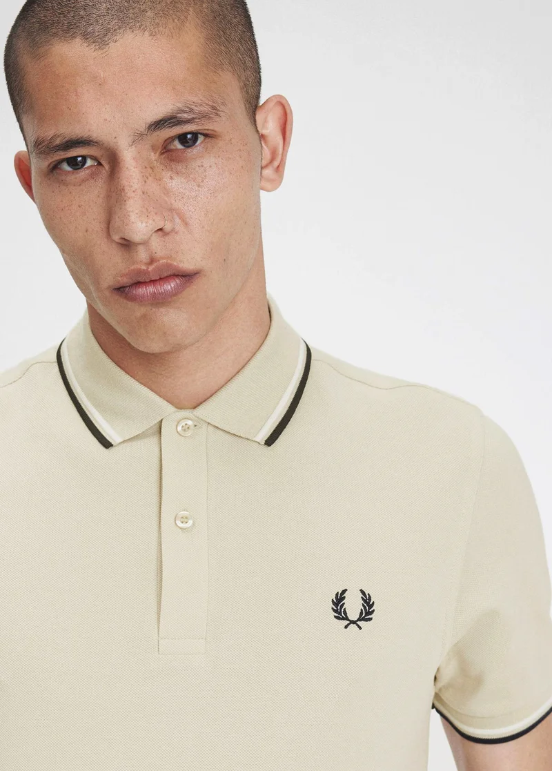 Male model wearing beige Fred Perry Shirt with white and black tipping