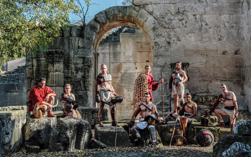 Gladiator reenactors pose amid Roman-era ruins in Arles, France. The equipment they use is based on archaeological finds.