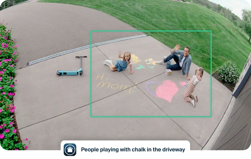 Simulated point of view image depicting a parent and two kids playing with chalk in the driveway. Simulated user interface elements overlay the image depicting an example of event captions that say: People playing with chalk in the driveway.