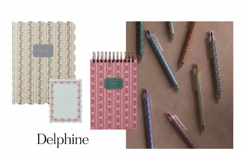 Delphine-patterned planner, notepad, and pens in soft floral stripes, with "Delphine" text at bottom.