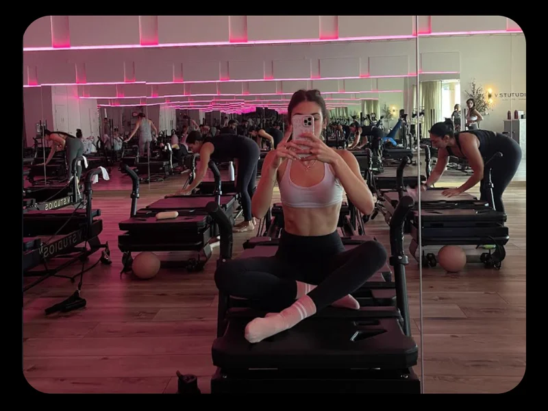 Marla sitting on a Pilates reformer