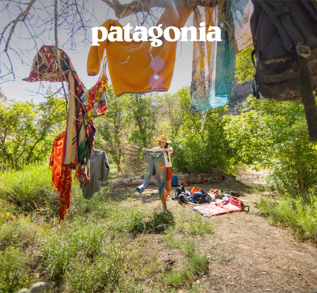 Patagonia. A person hangs their wet clothes on some branches by the bank of a river.