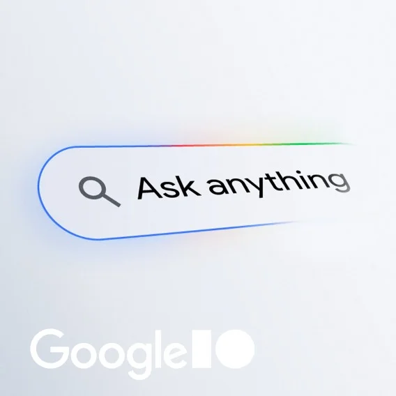 A Google search bar with a magnifying glass icon and the text Ask anything is prominently displayed. Below it, the Google I/O logo is visible. The background is a light gradient.