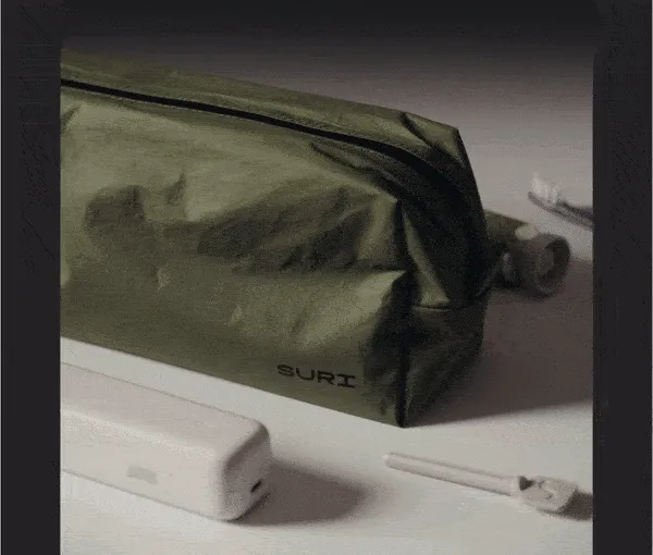 person packing their suri toothbrush and accessories into the suri washbag