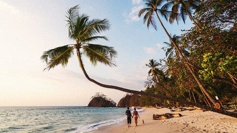 Image description: Couple walking on beach in Costa Rica