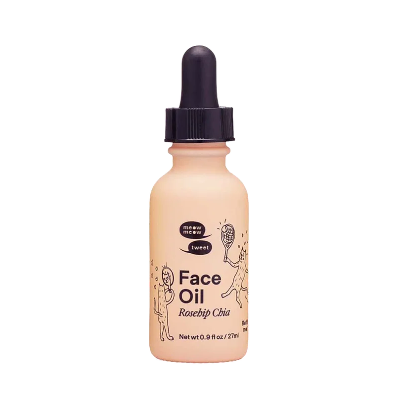 A pink glass bottle of face oil with a black dropper top.