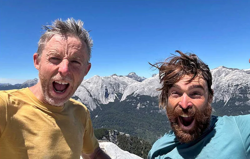 Two people looking really excited on top of a mountain.