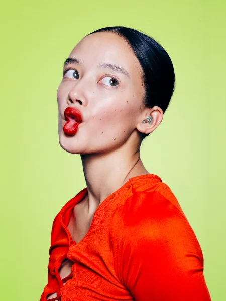 Woman wearing Bubble Blue Loop Kinetic earplugs making a funny face.