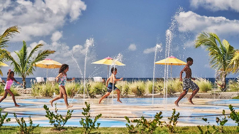 Image description: Kids playing in the pool area at the Four Seasons Resort Nevis.