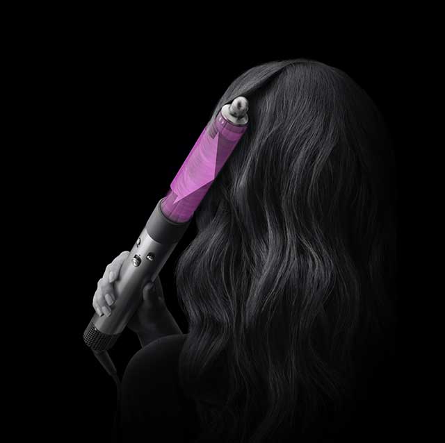 Model using the Dyson Airwrap multi styler to curl their hair