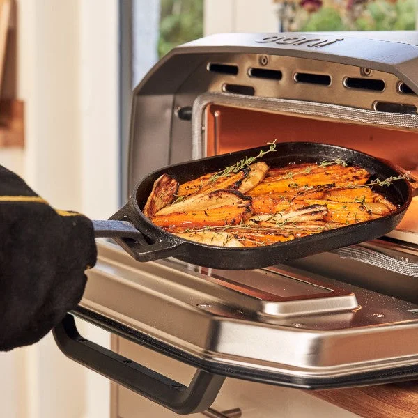 Volt being used inside with roasted carrots being cooked on an Ooni Cast Iron