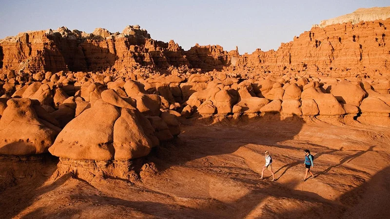 Image description: Two hikers in Goblin Valley State Park, Utah