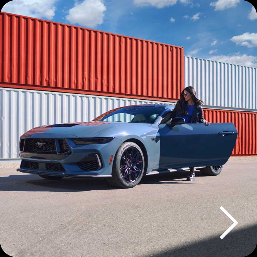 A woman standing by a 2024 Ford Mustang.