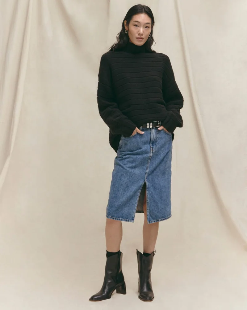 [Image] Model in The Oversized Turtleneck in Luxe Merino, The Mid-Way Skirt, and The Outlaw Boot
