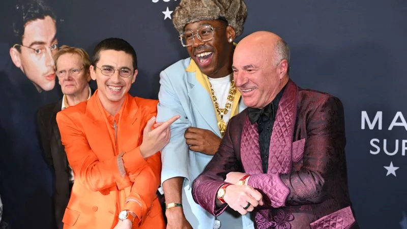 Image may contain: Tyler, The Creator, Timothée Chalamet, Clothing, Coat, Blazer, Jacket, Face, Head, Person, and Photography