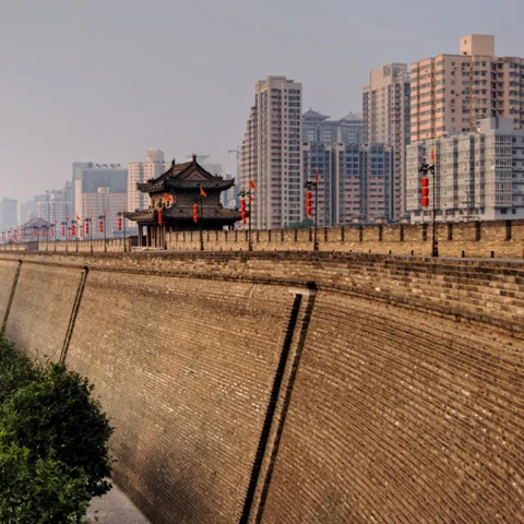 Big Xi'an city Walls with watch towers and gates with modern city buildings in distance.