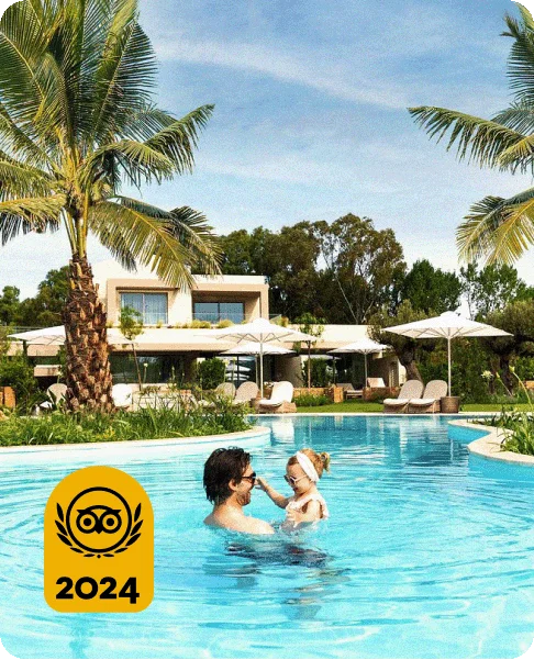 Image Description: A person holding a baby in a pool surrounded by palm trees. A gold 2024 Travelers’ Choice Award Best of the Best badge is on the bottom left corner.