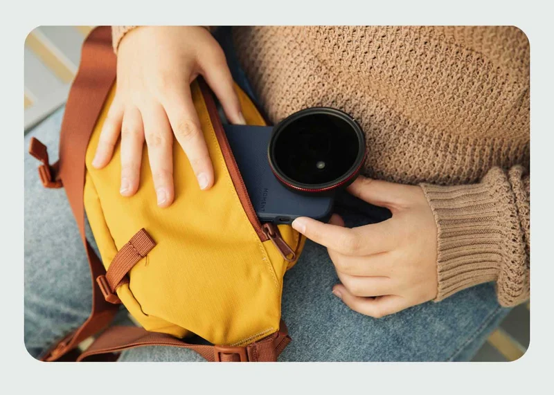 Image of someone removing a phone from a yellow Moment Sling