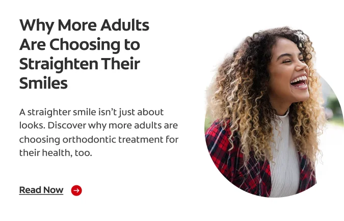 A woman with curly hair with a huge grin on her face, shows off her white teeth.
