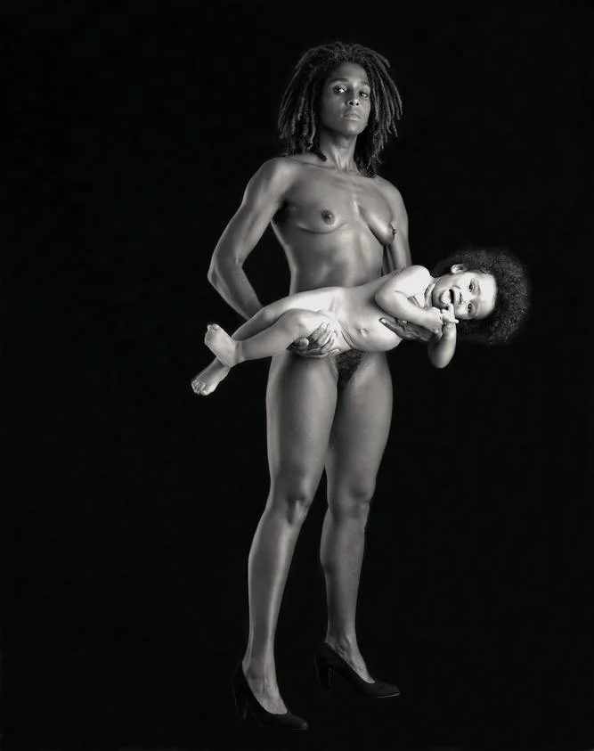 Black-and-white photograph of a nude woman in heels holding a baby
