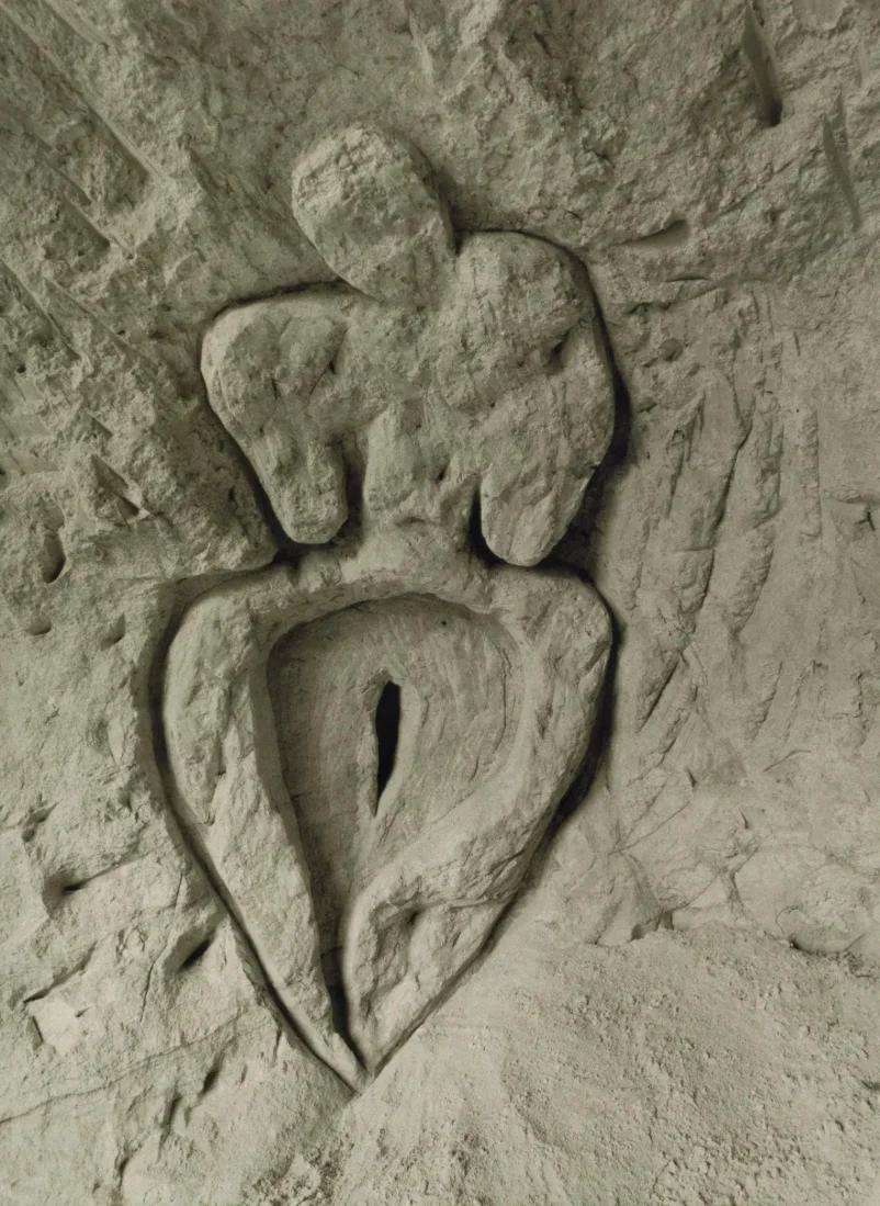 Photograph of a rock wall carving in the shape of a figure