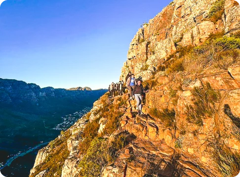 Image Description: People hiking a trail on a cliff.
