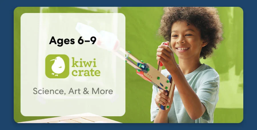 Young child smiling while working on a science experiment from KiwiCo Labs. Hands-on STEM learning for ages 6–9