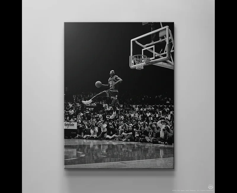 Black and white canvas of Michael Jordan soaring for a dunk during a crowded game. Black and white canvas of Michael Jordan soaring for a dunk during a crowded game.