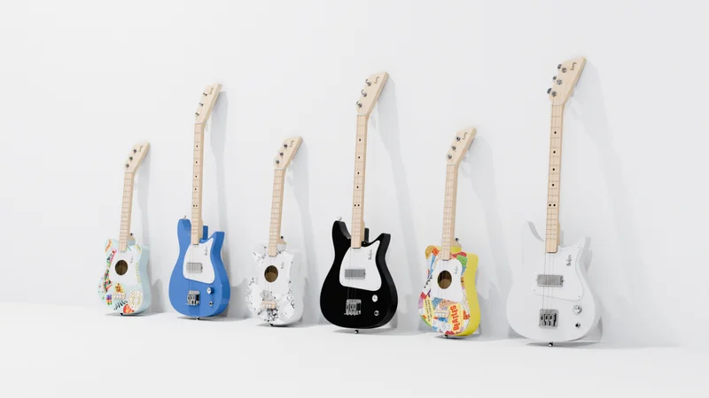 Six colorful guitars lined up against a white wall, each with Beatles + Loog unique designs.