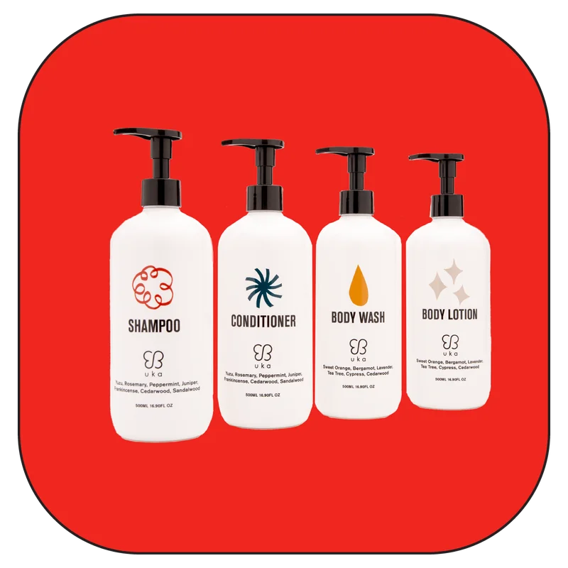 Set of Uka shampoo, conditioner, body wash, and body lotion with natural ingredients including yuzu, rosemary, and cedarwood.