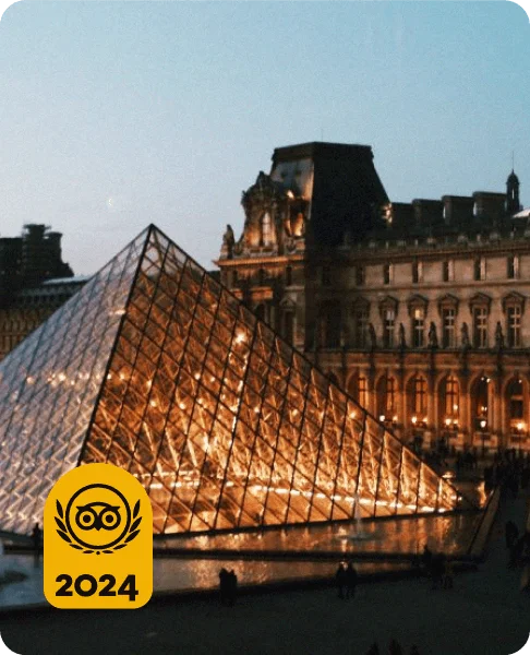 Image Description: Aerial shot of Paris’ iconic Louvre Pyramid illuminated at dusk