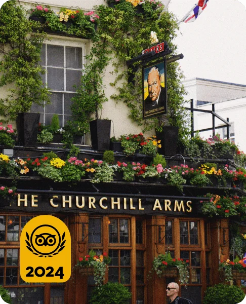 Image Description: A traveler passing by The Churchill Arms, a famous pub in London