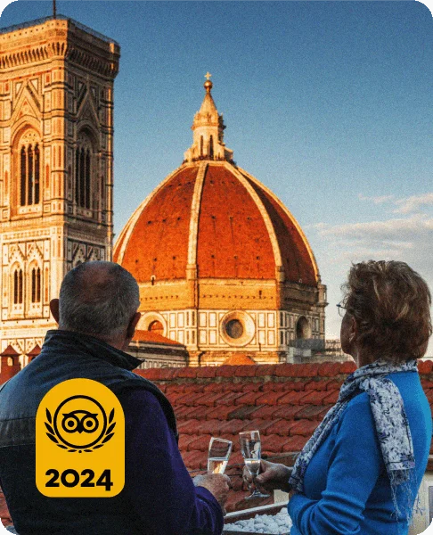 Image Description: Two travelers enjoying champagne while gazing at the orange domed roof of the Florence Cathedral