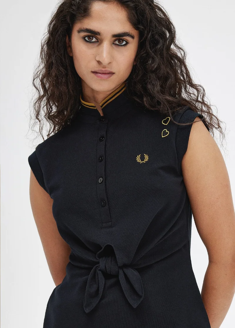 Female model wearing a black tie front dress from the amy winehouse collection