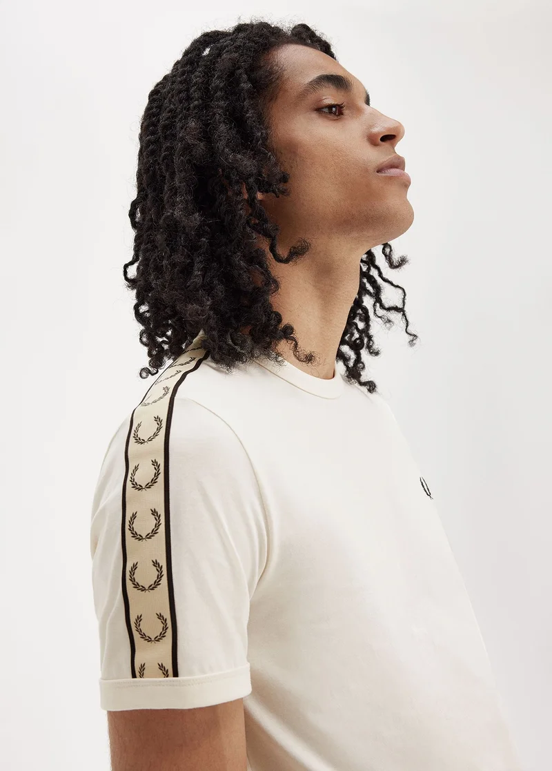 Male model wearing an ecru t-shirt with taping