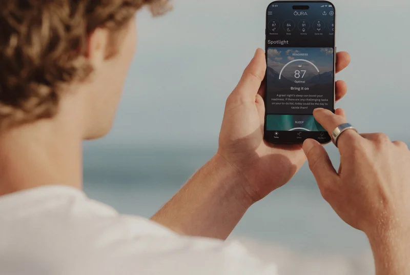 Person wearing Oura Ring using Oura app on phone