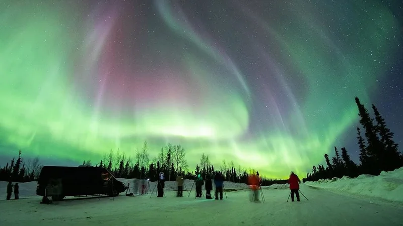 Image description: People taking photo lessons under the northern lights.