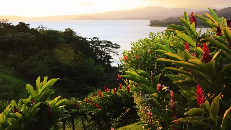 Image description: The view of Lake Arenal and Arenal Volcano behind clouds, in Costa Rica