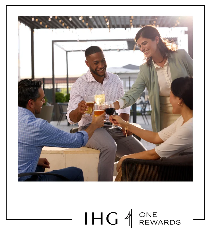 A group of workmates enjoying complimentary drinks on an outdoor patio.
