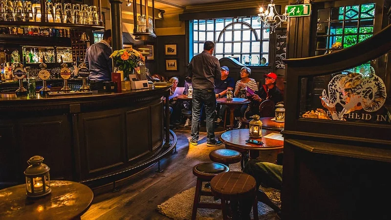 Image description: People having drinks inside The Sheep Heid Inn, Edinburgh.